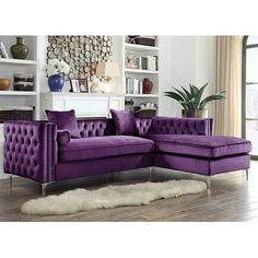 a purple couch sitting on top of a hard wood floor next to a white rug