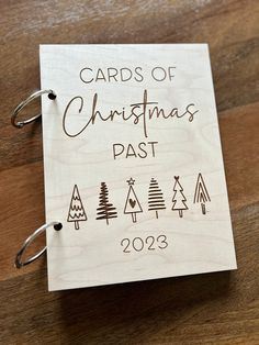 a wooden christmas card with the words cards of christmas past on it and trees drawn in brown ink