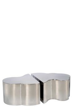 two metal tables sitting next to each other on top of a white surface with one table in the middle