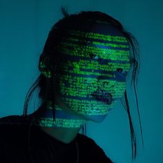 a woman with green and black text projected on her face