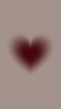 a red heart shaped object on a gray background with the light reflecting off it's side