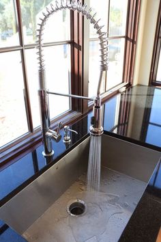 a stainless steel kitchen sink with faucet and water running from the faucet