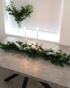 a table with candles and greenery on it