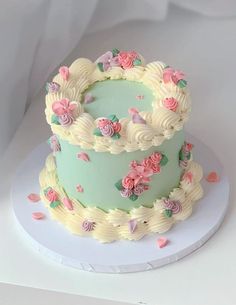 a three tiered cake with pastel frosting and flowers