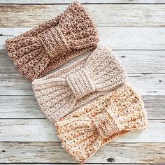 three crocheted pillows with bows on them sitting on top of a wooden floor