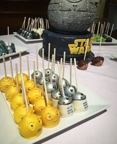 star wars themed cake pops are on a plate with toothpicks in the shape of spaceships