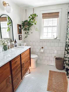 a bathroom with white tile and wooden cabinets