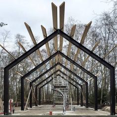 the inside of a building that is being constructed with wood beams and metal bars on it