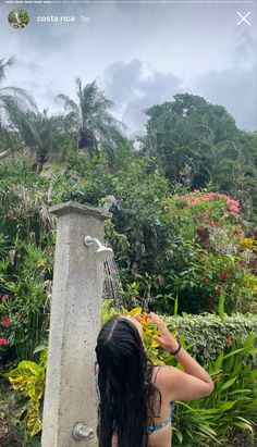 a woman in a bathing suit standing next to a fountain