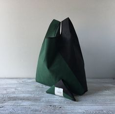 a black and green bag sitting on top of a wooden table next to a white wall