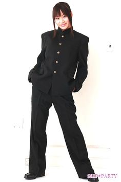 a woman in a black suit posing for the camera with her hands on her hips