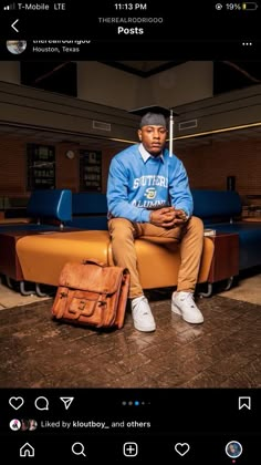 a man sitting on top of a couch next to a brown bag and a briefcase