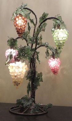 a lighted tree with fruit hanging from it's branches and leaves on the top