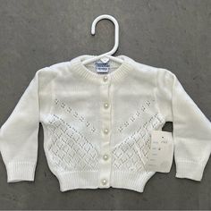 This Adorable Knit Sweater From Friedknit Creations Is Perfect For Any Occasion! With Faux Pearl Buttons And A Classic Crew Neckline, It's Both Stylish And Comfortable. The Long Sleeves And Button Closure Make It A Great Choice For Cooler Weather, While The Lightweight Knit Fabric Is Perfect For Summer And Spring. Available In Size 9-12 Months And A Crisp White Color, This Unisex Baby And Toddler Sweater Is Versatile And Can Be Worn For Travel, Weddings, Parties, Casual Outings, Formal Events, A Cute White Sweater With Buttons, White Knit Sweater For Playtime, White Cardigan For Winter Playtime, White Knitted Sweater For Playtime, White Winter Cardigan For Playtime, White Long Sleeve Cardigan For Playtime, White Knitted Button-up Outerwear, Baby Changing Mat, Toddler Sweater