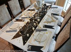 the table is set with black and white decorations, silverware, and wine glasses