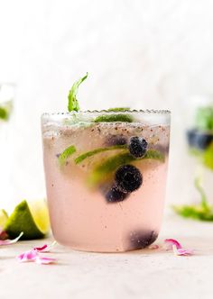 a close up of a drink in a glass with fruit on the rim and garnish