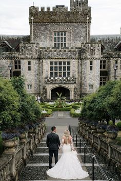 the bride and groom are walking down the stairs to their wedding reception at this castle