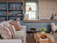 a living room filled with furniture and bookshelves in front of a large window