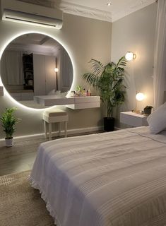 a bedroom with a large round mirror above the bed