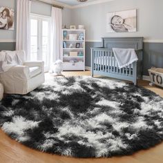 a baby's room with gray walls, white furniture and a black and white rug