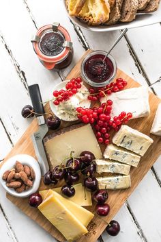 cheese, crackers and fruit on a cutting board