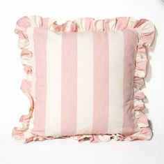 a pink and white striped pillow with ruffles on the bottom, against a white background