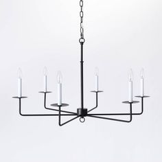 a black chandelier with six candles hanging from it