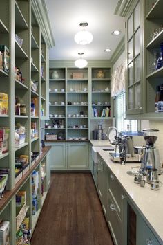 a kitchen filled with lots of green cupboards and counter top space next to a coffee maker