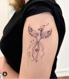 a woman's arm with a bird and stars tattoo on the back of her shoulder