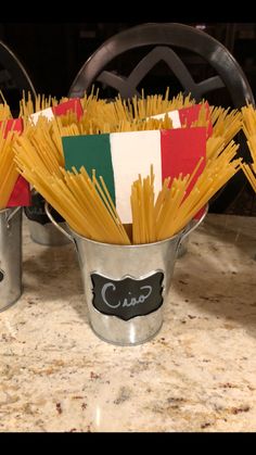 two buckets filled with pasta sitting on top of a counter