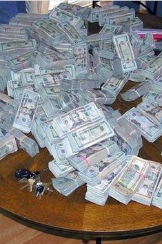 a pile of money sitting on top of a wooden table