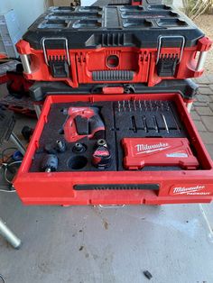 a red tool box filled with tools sitting on top of a table