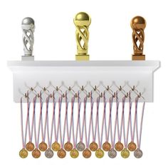 a row of trophies with ribbons and medals hanging from the top, on a white shelf