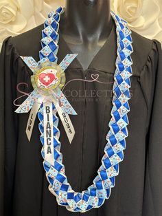 a black graduation gown with a blue and white ribbon around the neck that has a medal on it