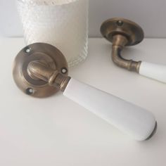 two bathroom faucets on a white counter next to a toilet paper dispenser