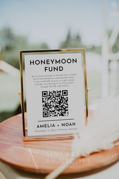 a wooden table topped with a qr code next to a white feather on top of it