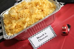 a tin pan filled with macaroni and cheese sitting on top of a table