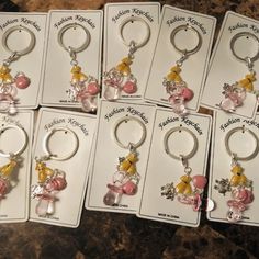 six key chains with charms on them sitting in front of a package for $ 10