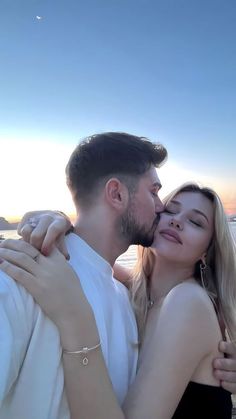 a man and woman embracing each other on the beach