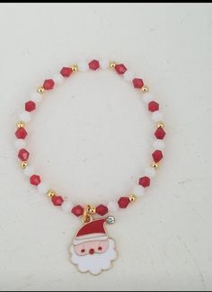 This adorable Santa charm bracelet is made with a metal alloy and enamel santa charm with a 304 stainless steel jump ring.  The rest of the bracelet is made with red and white  bicone beads accented by real 14k gold plated ball beads. You can also choose gold filled beads from the drop down menu.  This bracelet is made to be non tarnish and water resistant.  Made to order so please select size from the drop down menu.  If you like the charm but want to change the pattern of the beads, feel free Christmas Jewelry Diy, Custom Charm Bracelet, Christmas Hair Accessories, Beaded Memory Wire Bracelets, Crystal Bead Jewelry, School Jewelry, Santa Face, Christmas Bead, Beads Bracelet Design