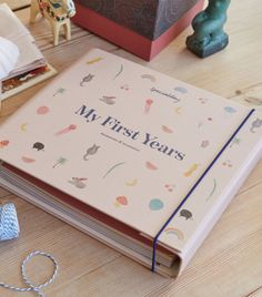 an open book sitting on top of a wooden table next to other books and toys