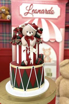 a teddy bear sitting on top of a red and green cake