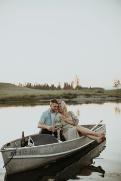 a man and woman sitting in a small boat on the water with their arms around each other