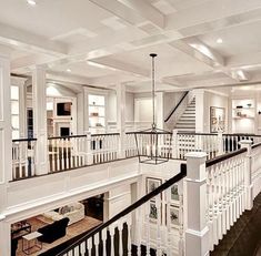 a large white house with black railings and wood flooring on the second story