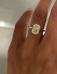 a woman's hand with a yellow diamond ring on it