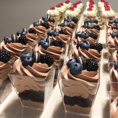 there are many cupcakes with chocolate frosting and berries on top