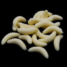 several pieces of white pasta on a black surface