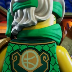 a close up of a lego figure wearing a green and yellow outfit with white hair