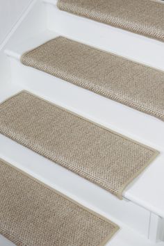 three beige carpeted steps leading up to a white door