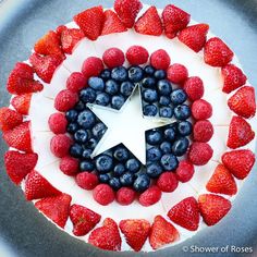 a cake decorated with strawberries and blueberries in the shape of an american flag